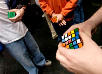 Jóvenes participantes en una competición del cubo de Rubik ensayan poco antes de enfrentarse.