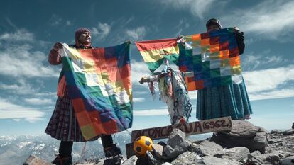 Dos cholitas muestran la whipala, la bandera de los pueblos indígenas andinos, en la cima del Aconcagua.