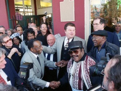 Foto de diciembre de 1999 de Dave Bartholomew (izquierda), que estrecha la mano de Fats Domino (en el centro con gafas y kepi).