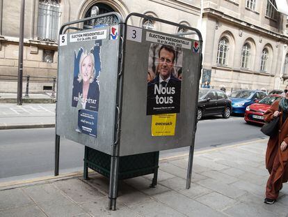 Una mujer pasa junto a carteles electorales del presidente Emmanuel Macron y de la líder de ultraderecha Marine Le Pen, en París, el 29 de marzo.