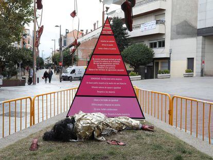 La maniquí junto a la pirámide de la discriminación.