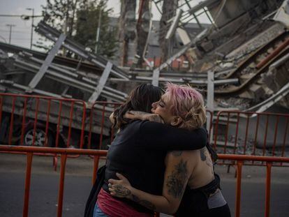 Dos mujeres lloran la perdida de una amiga frente a donde ocurrió el accidente de la linea 12 del metro en Ciudad de México el día 08 de mayo de 2021.