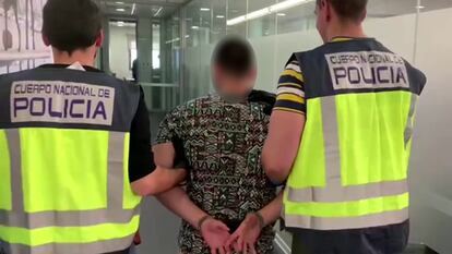 Imagen de uno de los detenidos, conducido por dos agentes.