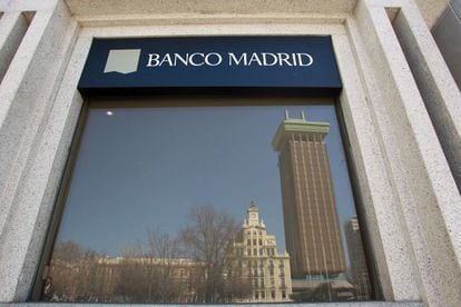 Los edificios de la Plaza de Colón se reflejan en una ventana del Banco Madrid.