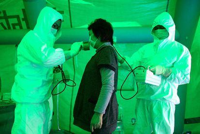 Personal médico mide la radiación de una mujer en un centro público en la ciudad de Hitachi.