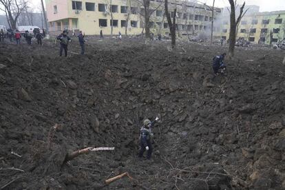 El presidente Volodymyr Zelenski escribió en Twitter: "Ataque directo de las tropas rusas al hospital de maternidad. Hay personas, niños bajo los escombros. ¡Atrocidad! ¿Cuánto tiempo más será el mundo cómplice ignorando este terror? Cierren el espacio aéreo ya". En la imagen, varios soldados ucranios y empleados de emergencias trabajan en el desalojo y la evaluación de daños en Mariupol.