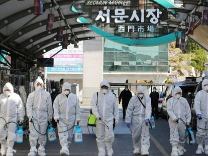 Un grupo de trabajadores desinfecta un mercado en Daegu, Corea del Sur, este domingo.