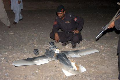 Soldados pakistaníes inspeccionan un 'drone' de EE UU, derribado.
