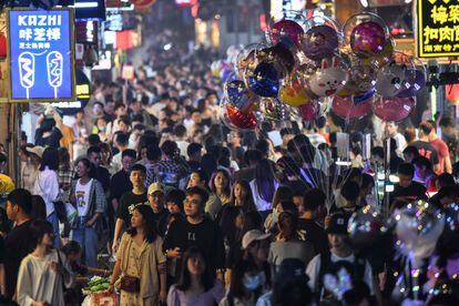 Peatones en una calle llena de gente en la ciudad china de eatones en una calle llena de gente rodeada de pequeñas tiendas en la ciudad de Changsha.