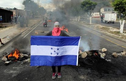 Un manifestante posa con la bandera hondureña hoy en Tegucigalpa