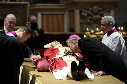 El arzobispo Georg Gänswein, que fuera secretario personal de Benedicto XVI, besa su mano en la capilla ardiente instalada en la basílica de San Pedro.
