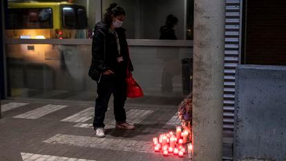 Una mujer mira anoche el altar en recuerdo del enfermero Sergio García, en el acceso a las urgencias del Hospital Príncipe de Asturias de Alcalá de Henares.