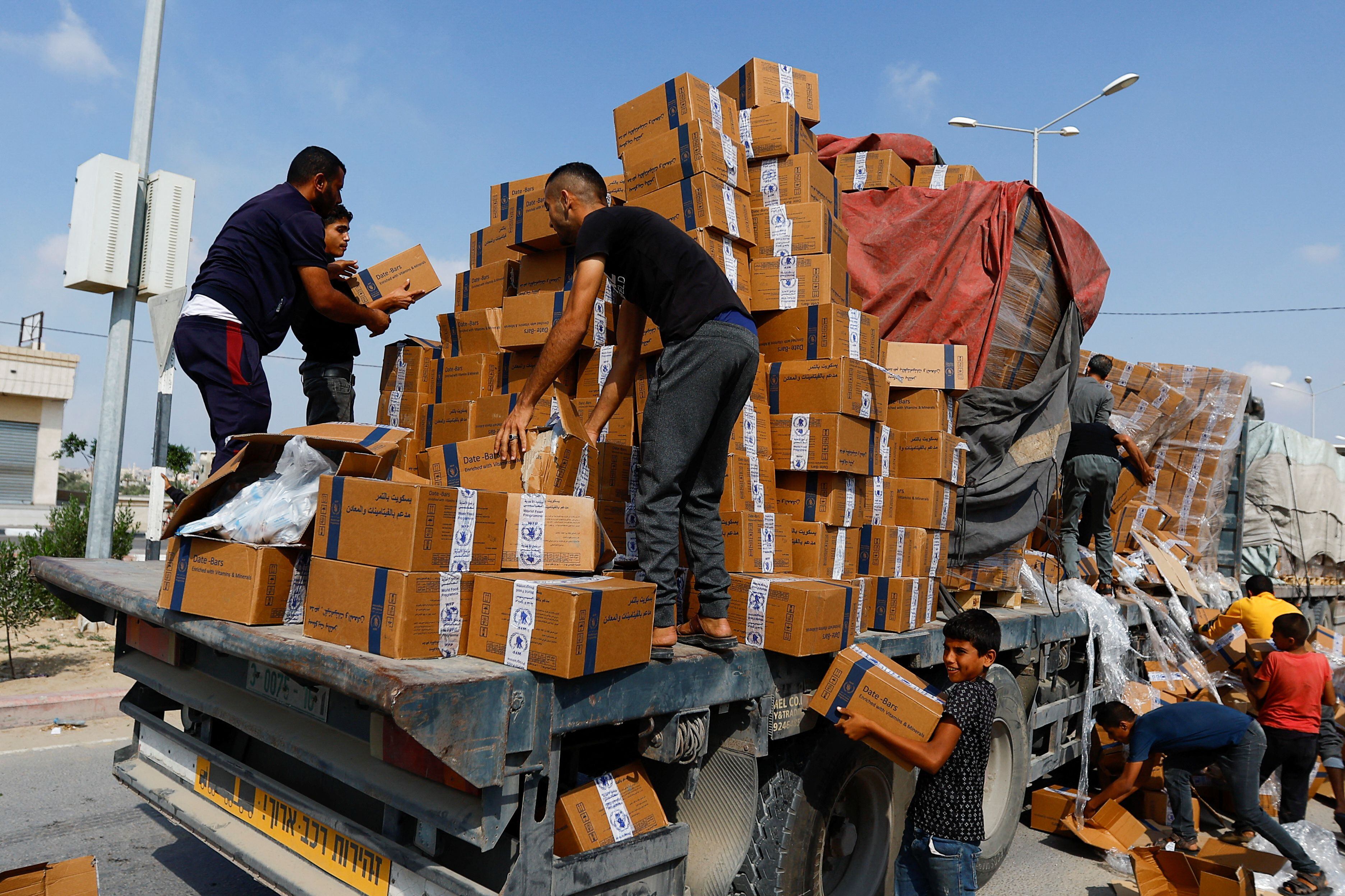 Varios palestinos recargan un camión con ayuda en Rafah, en el sur de la Franja, este jueves.