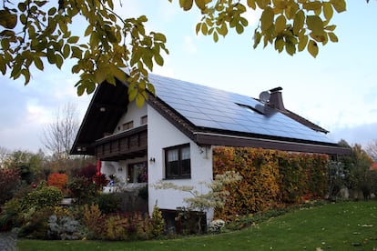 Placas solares en el tejado de una casa unifamiliar. El proyecto se integra tanto en el entorno urbano como en el rural.