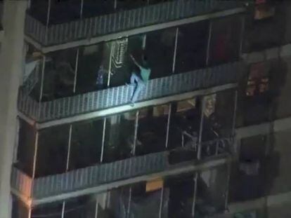 El hombre escalando el edificio por su zona exterior.