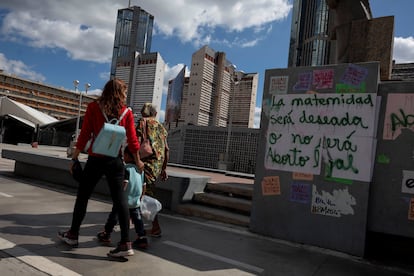 Una familia camina frente a un letrero a favor del aborto legal en Caracas, el 16 de enero.