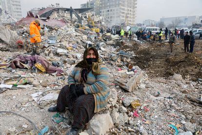 Una mujer sentada junto a los restos de un edificio colapsado en Kahramanmaras (Turquía), este viernes. 