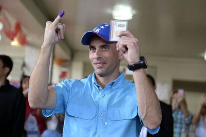 El líder de la oposición venezolano Henrique Capriles muestra su dedo meñique teñido tras votar en las elecciones legislativas, en Caracas.