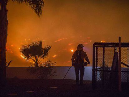 Un bombero intenta proteger una casa en Lilac, cerca de Santa Ana (California).