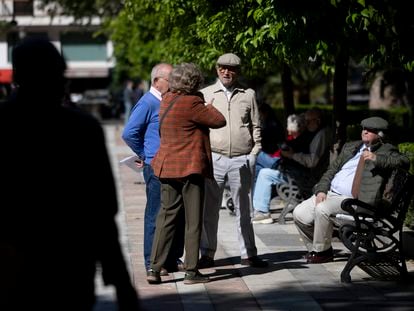Un grupo de personas mayores conversando en un parque en Sevilla.