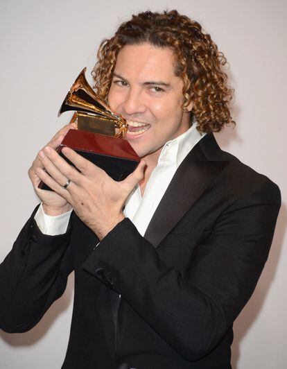 David Bisbal mordiento su preciado Grammy.