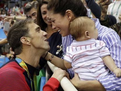 Michael Phelps, a la izquierda, se felicita junto a su novia, Nicole, y su hijo, Boomer, tras ganar los 200m mariposa.
