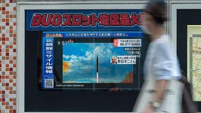 Una mujer pasa ante una pantalla en Tokio donde se informa sobre el lanzamiento de misiles por Corea del Norte, este martes.