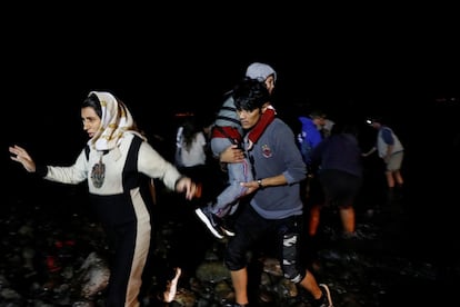 Migrantes afganos desembarcan de un bote en una orilla cerca de la aldea de Skala Sikamias, el pasado enero en la isla de Lesbos (Grecia).