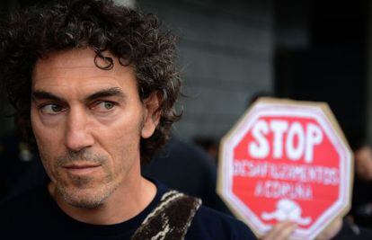 El bombero y activista Roberto Rivas, ante un cartel antidesahucios