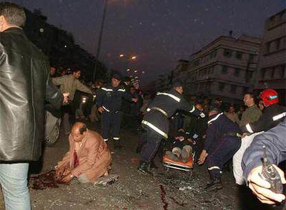 Un policía (de rodillas) busca entre los restos de un terrorista suicida que causó anoche 19 heridos en el barrio de El Fida, en Casablanca.