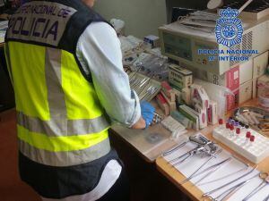 Un policía recoge medicamentos en una clínica ilegal.