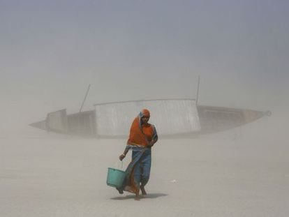 Una mujer india carga con agua cerca del río Brahmaputra, en Gauhati (India).