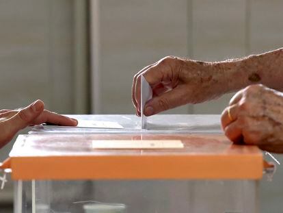 Una persona deposita su voto en el Colegio Cristo Rey en Madrid durante la jornada de elecciones generales.