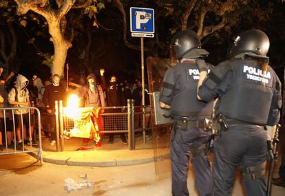 Unos manifestantes queman una bandera de España en el perímetro de seguridad alrededor del Parlament en 2017.