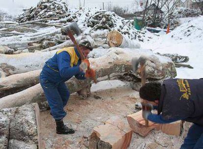 Dos trabajadores bosnios cortan leña ante la falta de gas en Sarajevo.