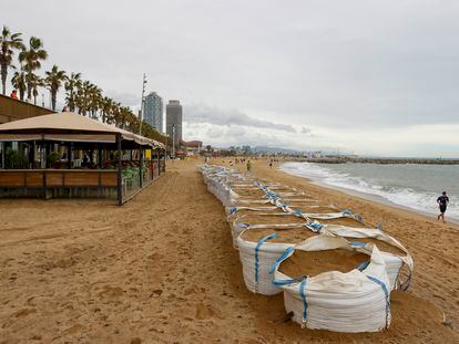 Sacos llenos de arena para proteger la playa de la Barceloneta este domingo.
