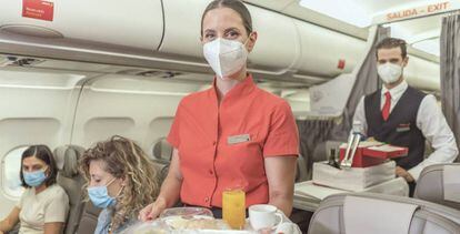 Viajeras y TCPs con mascarilla a bordo de un avión de Iberia.