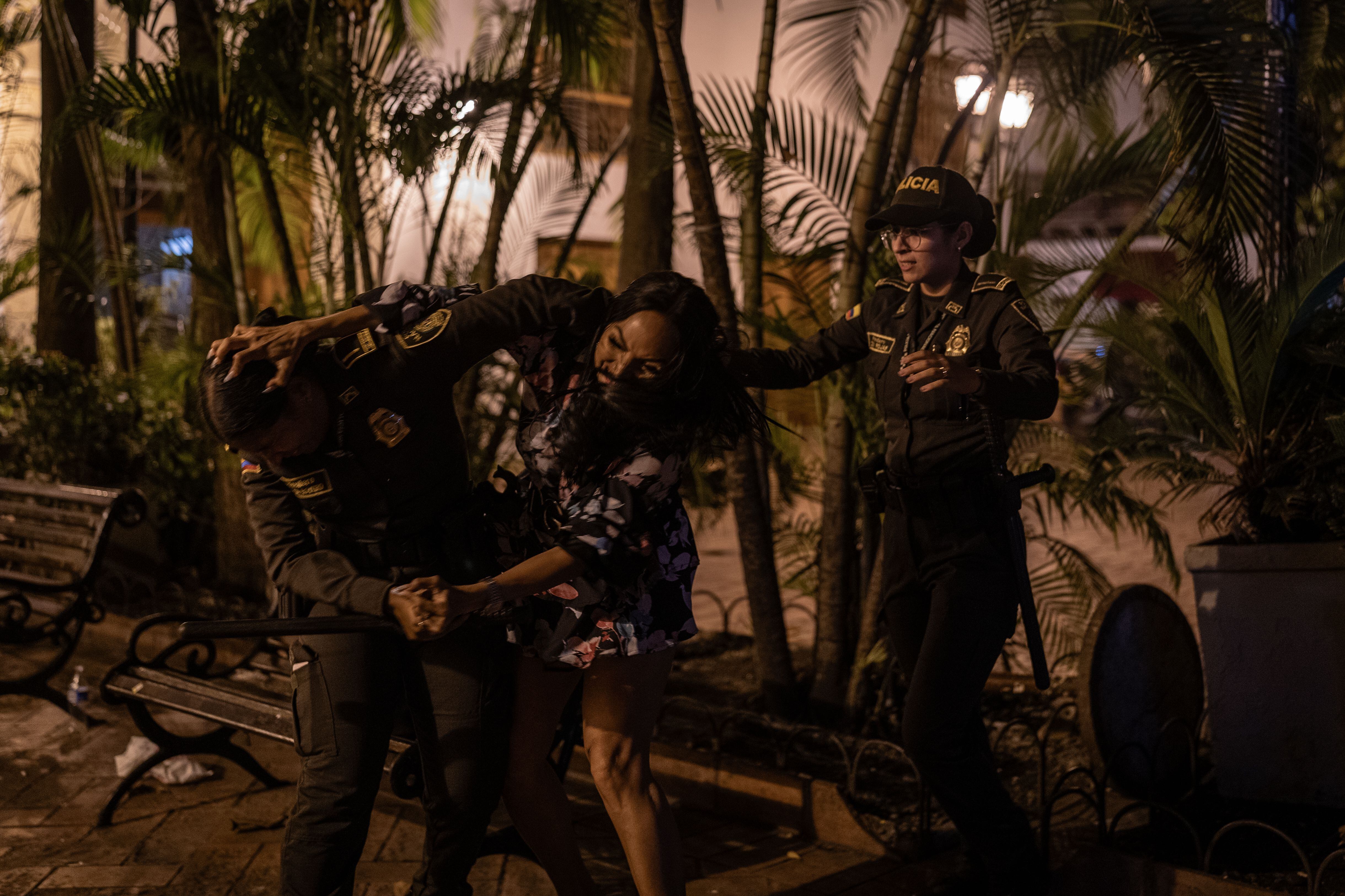 Una trabajadora sexual forcejea con la policía tras ser retirada de una banca en el Centro Histórico de Cartagena, el 22 de febrero.