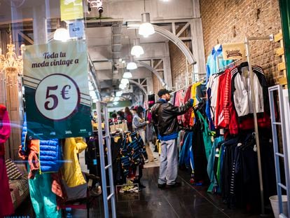 Varios jóvenes buscan ropa de segunda mano en la tienda Humana Vintage de la calle Hortaleza de Madrid.
