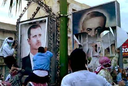 Un grupo de manifestantes rompe carteles de los Asad en Hama en una imagen sacada de un vídeo.