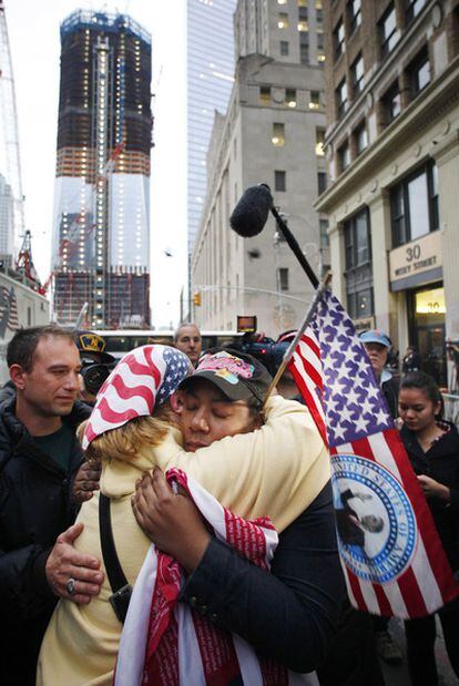 Dos personas se abrazan ante el nuevo World Trade Center en obras.