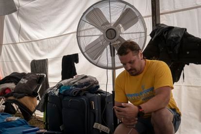 Denis conecta su celular en una de las carpas del campamento. 