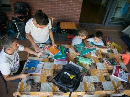 Karima y su marido, Dani, revisan el material escolar de sus tres hijos para el nuevo curso en su casa del barrio madrileño de Villaverde.