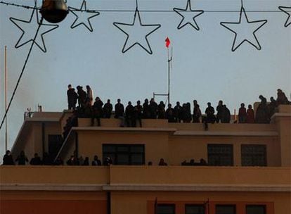Ocupantes de la Facultad de Derecho de Atenas contemplan desde la terraza del edificio los disturbios surgidos el jueves tras una protesta.