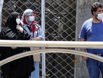 Dos mujeres y un hombre con mascarilla en Teherán, capital de Irán.