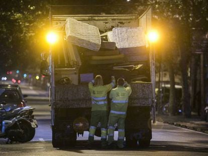 Operarios de FCC recogen muebles y trastos viejos en el distrito del Eixample de Barcelona.