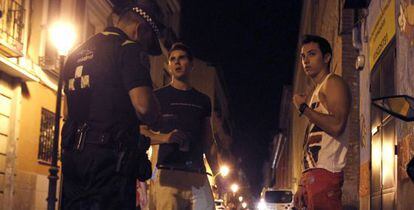 Un policía municipal multa a dos jóvenes en la calle de Pelayo.