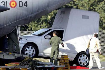 Unos operarios desembarcan,  ayer , en el aeródromo militar de Lavacolla, el vehículo que usará Ratzinger en Santiago.