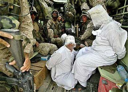 Un grupo de <i>marines</i> de Estados Unidos vigila a unos iraquíes detenidos cerca de la ciudad de Faluya.