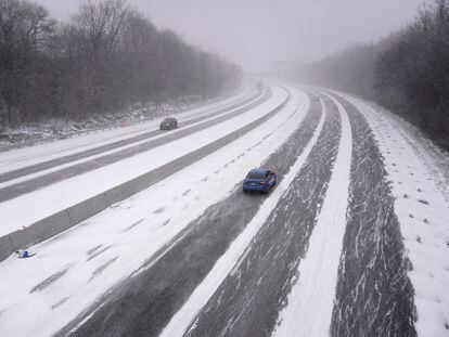Dos coches avanzan sobre el hielo y la nieve en la interestatal 44, en el Estado de Misuri, este viernes.